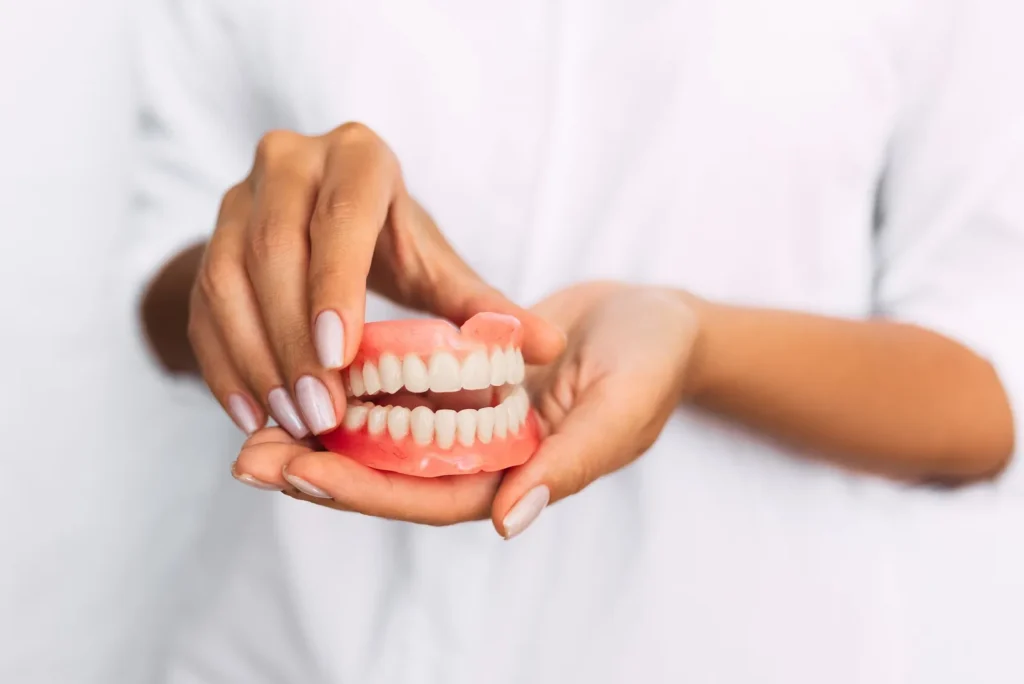 A full denture held in two hands